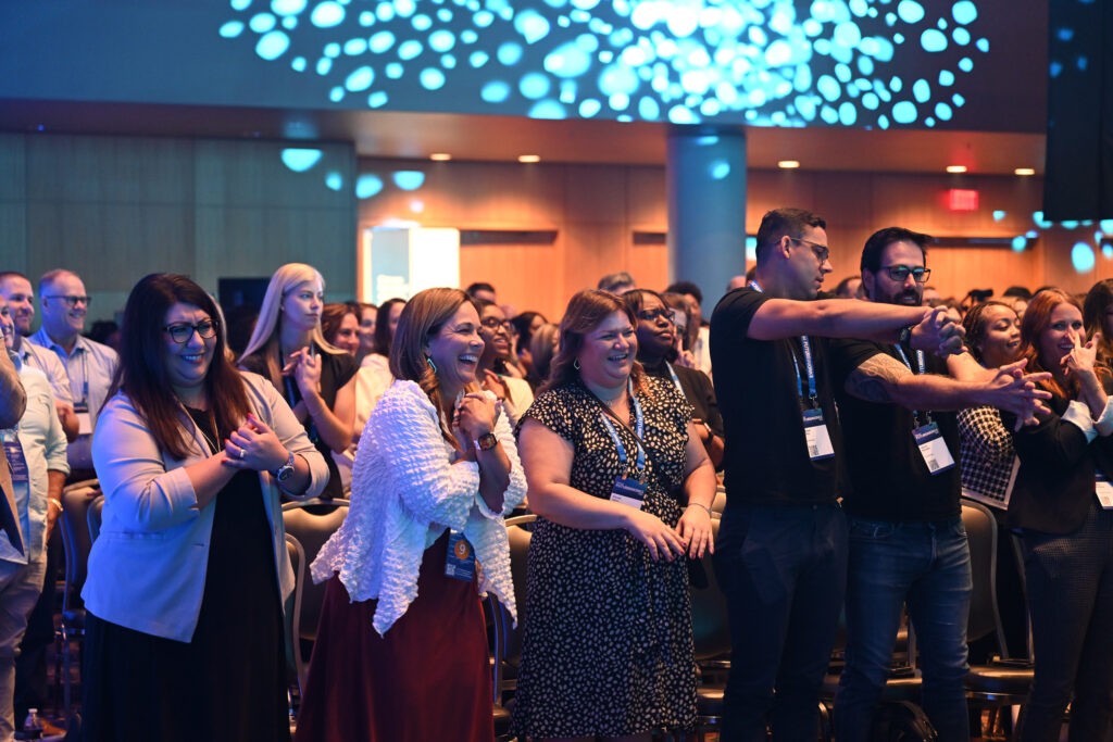 A row of people attending the conference participating in a moving meditation exercise.