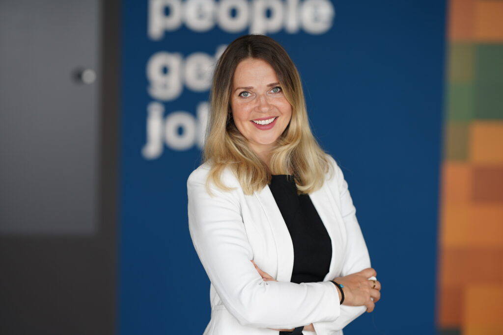 woman standing in office building with arms crossed