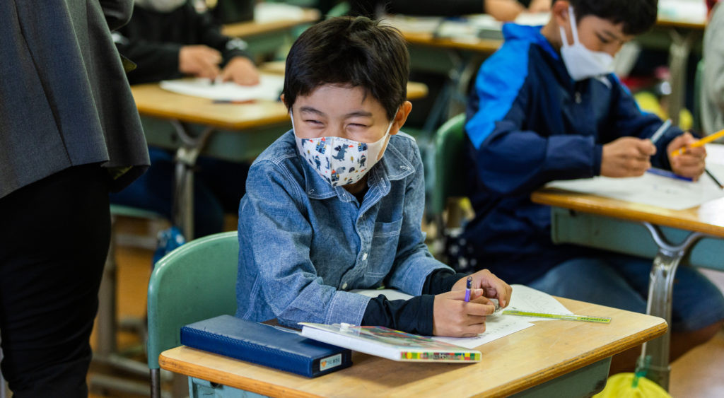 クラスメイトと笑顔で話をする男子生徒