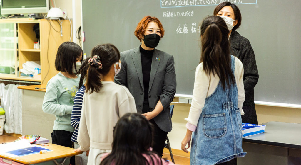 授業が終わった後に生徒たちと談笑するIndeedの佐藤とアリソン