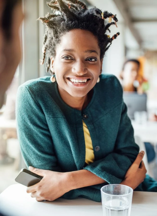 Smiling businesswoman sitting with male colleague at table in office cafeteria
