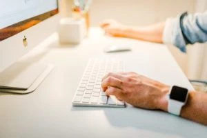 A person typing on a desktop computer