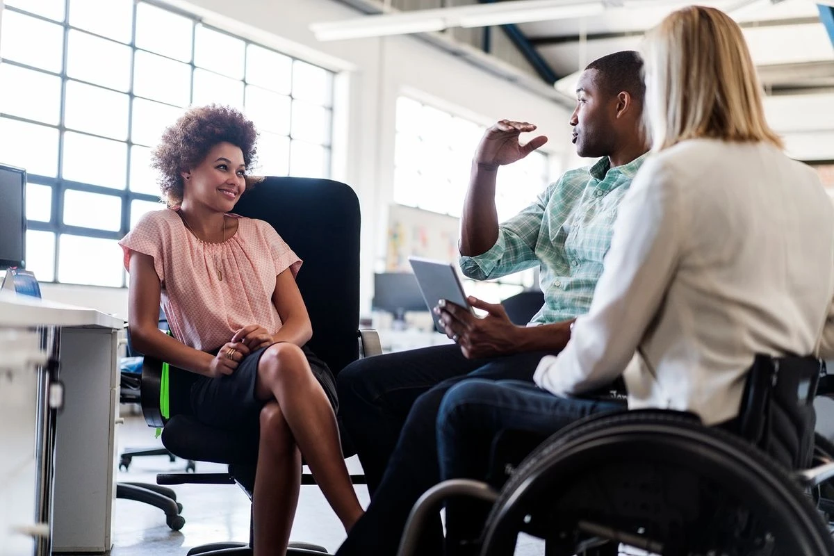 Three professionals having a casual seated conversation.