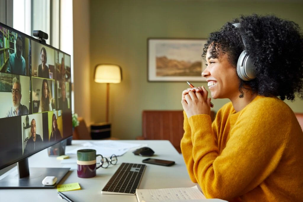 woman smiling with headset on looking at desktop