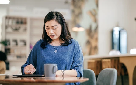 Woman at coffee shop looking at tablet