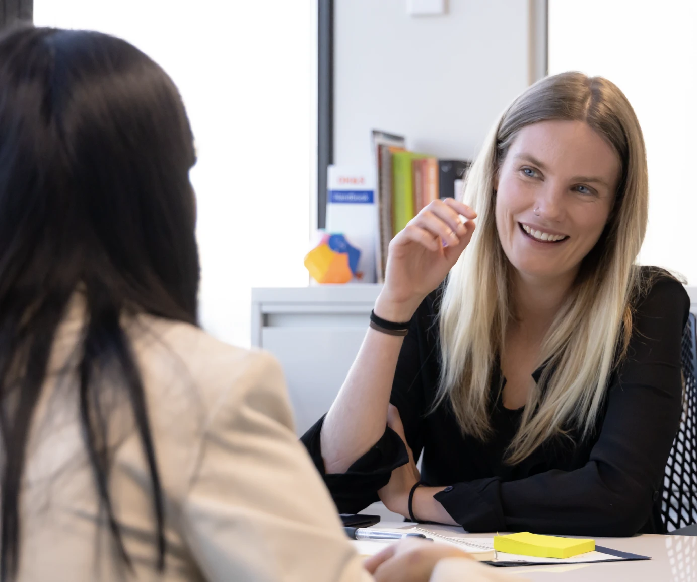 Two people talking at a table in an office setting