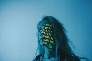 Headshot of woman looking into the distance with a digital projection of binary code on the side of her face