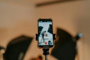 a mobile phone on a stand in a photo studio with a person on the screen