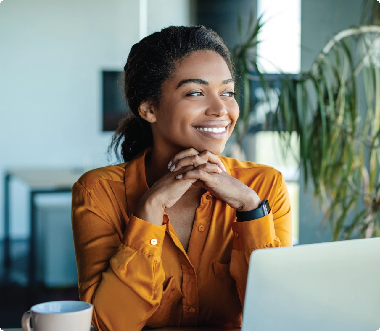 woman smiling in at her desk with laptop