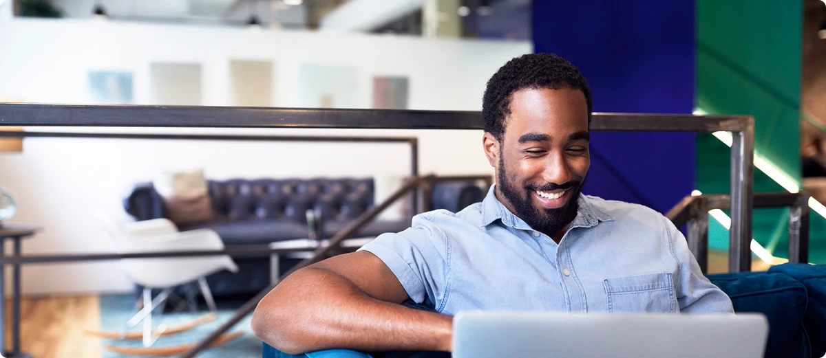 Man smiles looking at laptop