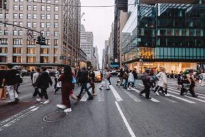Many people crossing the street in a large city