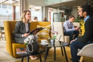 Caucasian female real estate agent meeting a Middle Eastern client in a cafe.