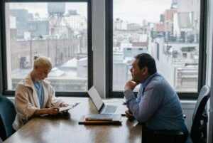 Two employees meeting in city office with laptop