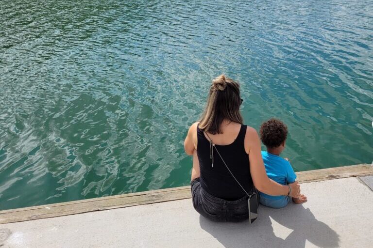 woman sitting with small child looking over a lake