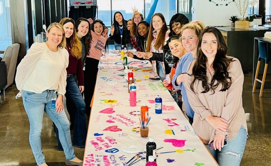 Members of Women at Indeed standing at a table together