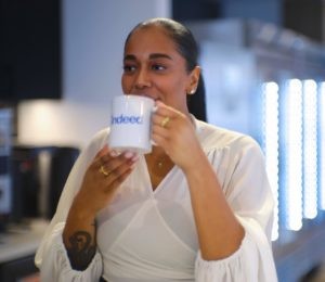 Makayla drinking out of an Indeed coffee cup