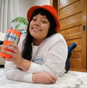 Miracle posing with her Indeed cup, shirt, and socks 