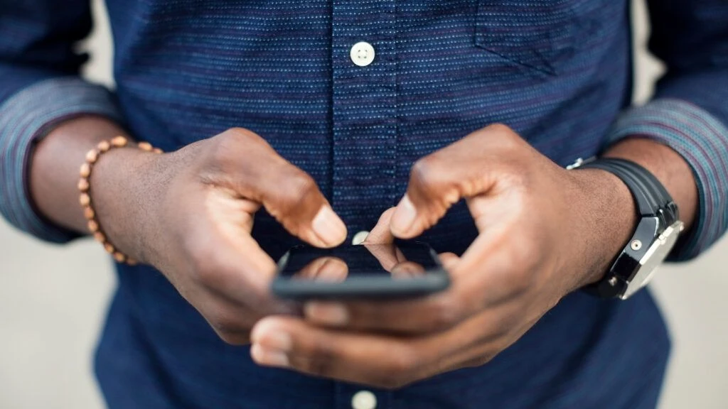 Person typing on phone