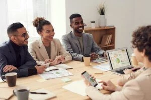 A panel of interviewers speaking with a job candidate across a table in meeting room