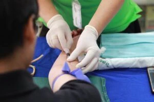 A phlebotomist drawing blood from a patient.