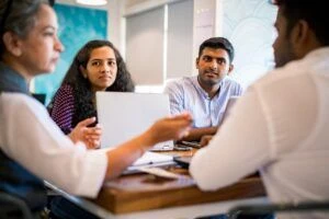 A group of professionals conducting a meeting at a corporate office.