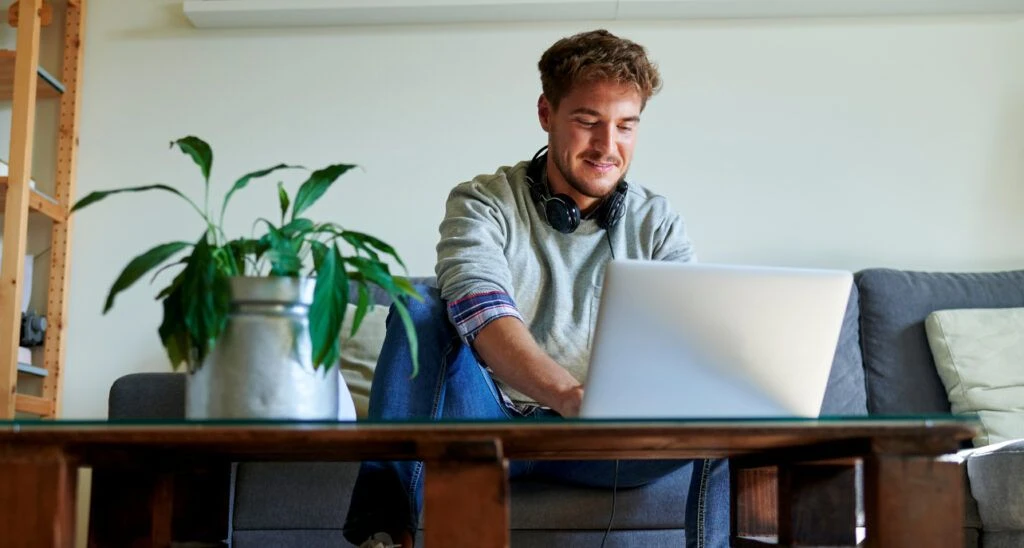 Man working on his laptop, smiling