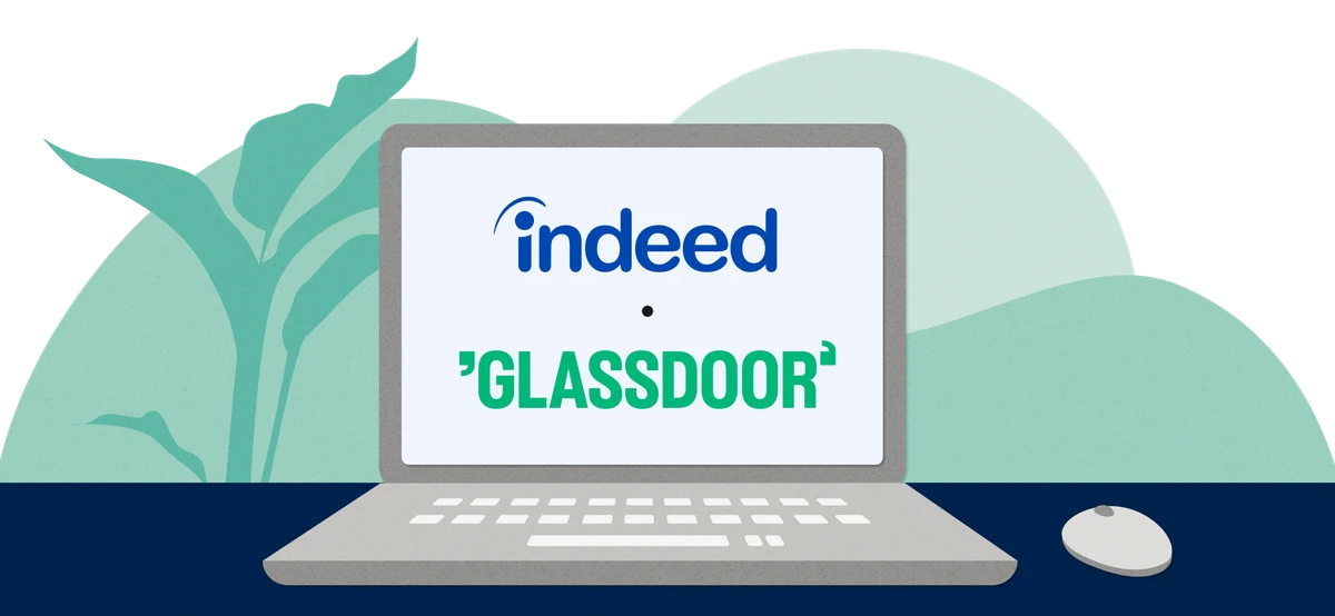 A laptop open on a desk, featuring the Indeed and Glassdoor logos on its screen