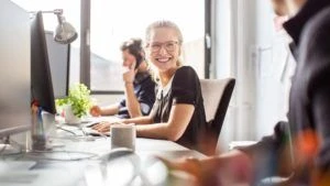 Women at a desk smiling