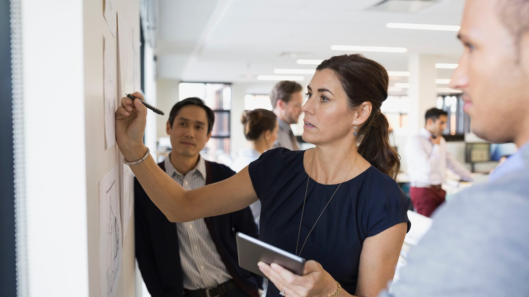 Businesswoman writing at wall