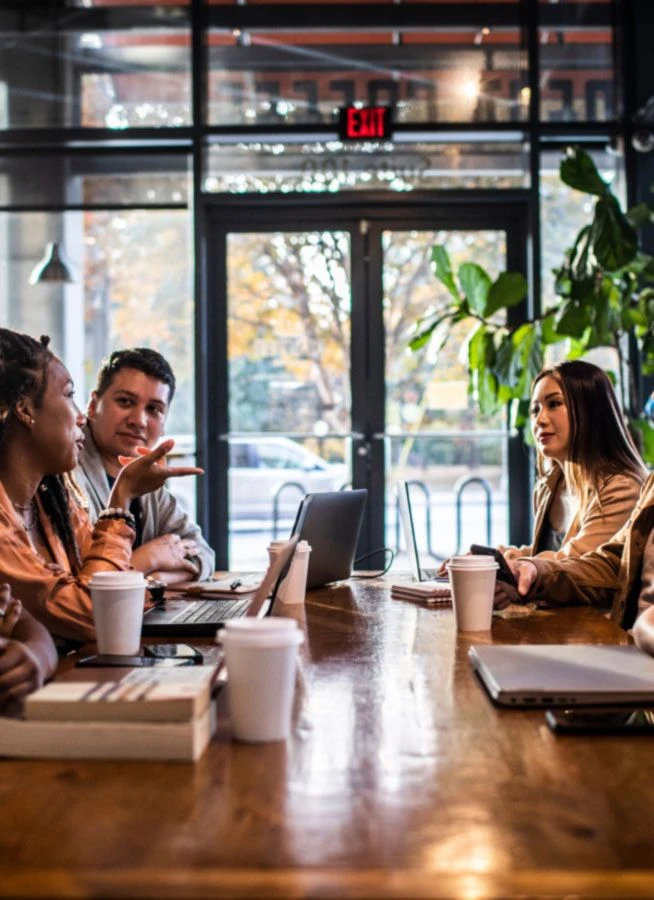 People sitting around a table at a cafe working