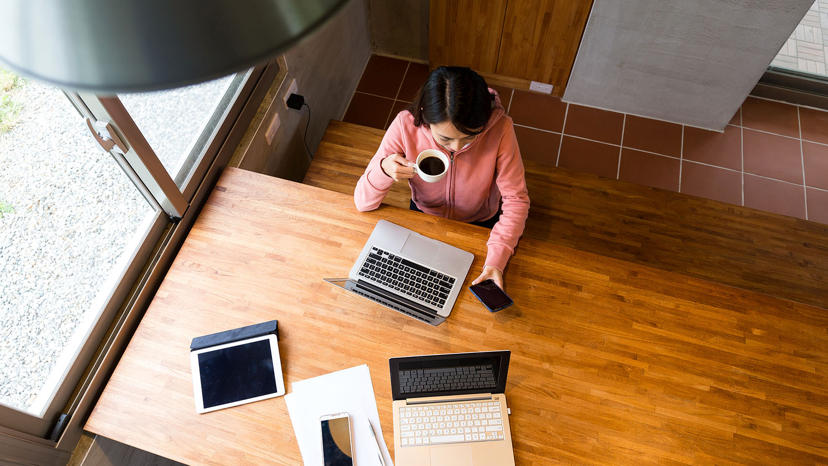 An overhead view of a woman looking at her laptop in a meeting room