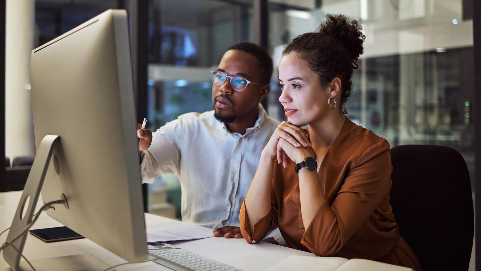 A man and a woman looking at a computer screen