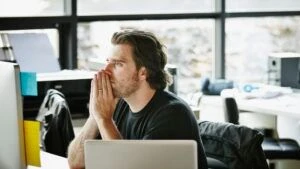 AI Skeptical Candidate folding hands at computer