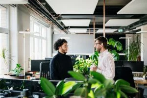 Two Colleagues Talking In Bright Modern Office Space