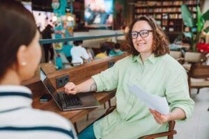 Smiling female, ceo hiring woman manager with laptop interviewing with job applicant