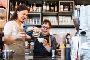Young woman with Down Syndrome working at cafe preparing coffee