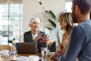 A senior leader smiling and conversing with her coworkers in an office
