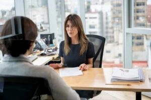 A sales manager in her office talking to an employee at her desk