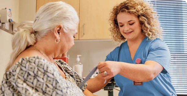 Une professionnelle de la santé qui prépare le bras d'un patient pour une prise de sang.
