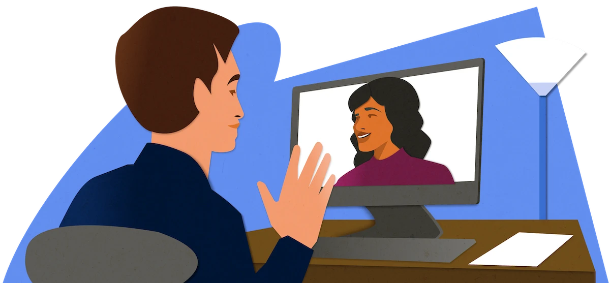 Person sitzt am Schreibtisch vor einem Monitor und führt ein Videogespräch mit einer lächelnden Bewerberin, Symbolbild für Online-Vorstellungsgespräche mit Indeed Interview