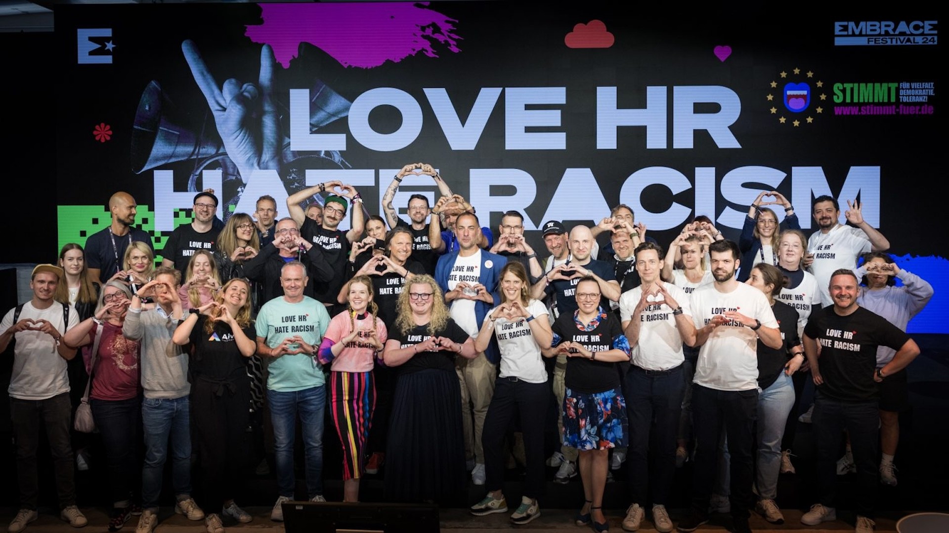 Gruppenbild der Teilnehmer des embrace Festivals mit Herz Geste