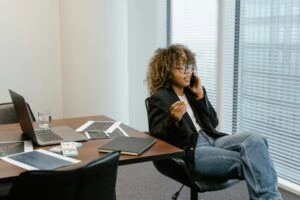 Frau sitzt am Schreibtisch und telefoniert