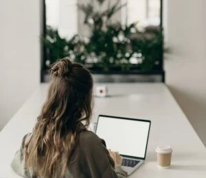 Woman working on laptop in front of a mirror