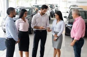 Latin American sales team in training at a car dealership – business concepts
