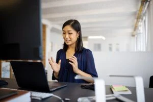 Een vrouw die op haar laptop werkt in een kantoor