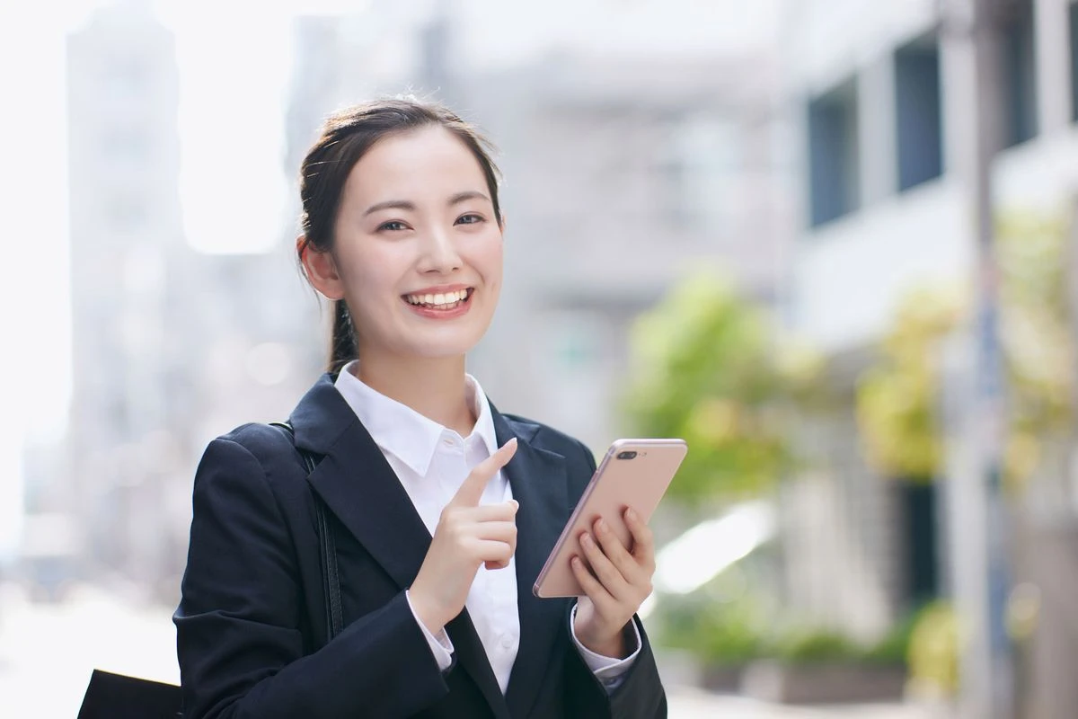 スマホを持って笑う若い女性