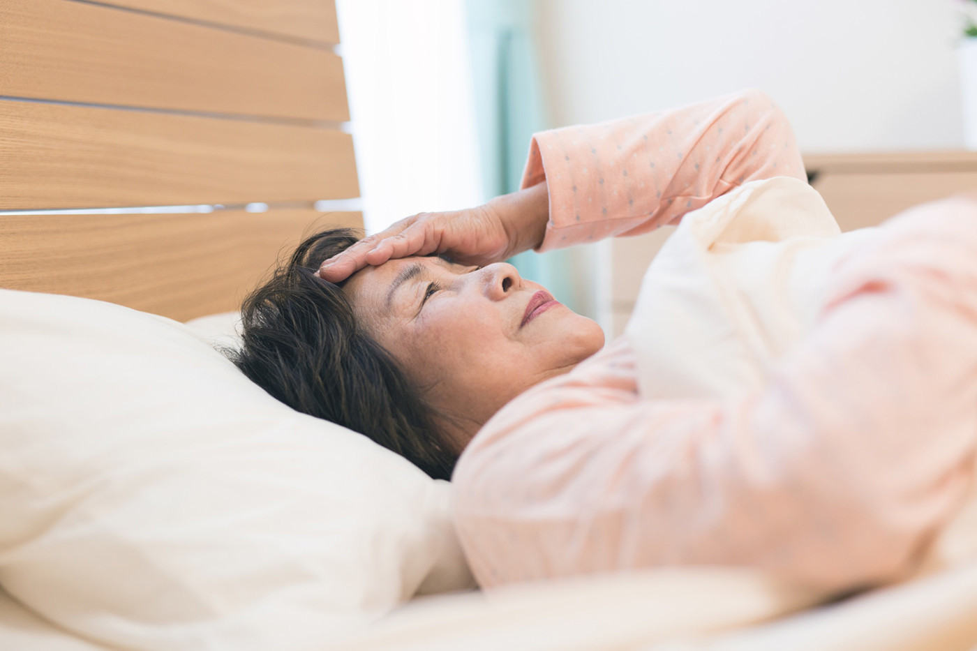 ベッドの上で寝ている女性