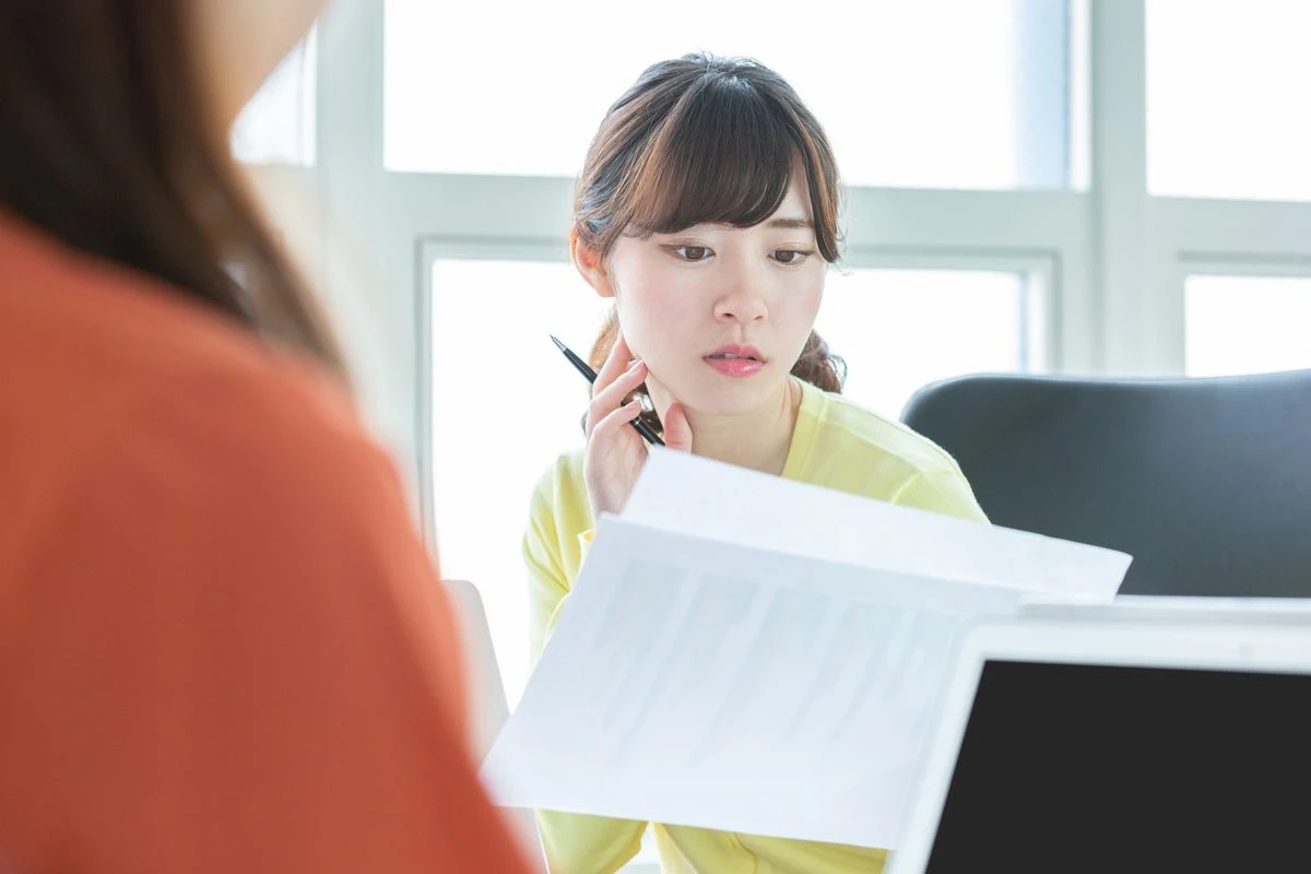 手に持った書類を眺める女性