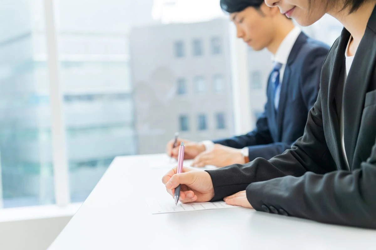 会社で筆記試験を受けている様子