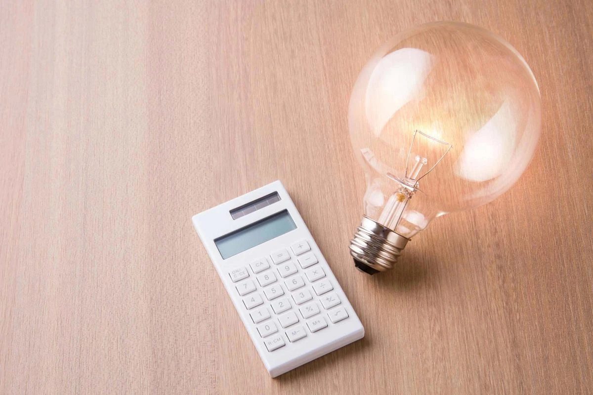 机の上にある電卓と電球のイメージ
